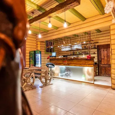 a bar in a wooden room with a bench and wine glasses at Власовъ in Pamporovo