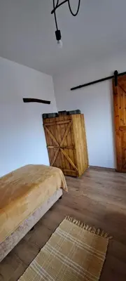 a bedroom with a bed and a wooden floor at апартамент Гигови in Bansko