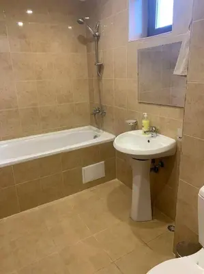 a bathroom with a sink and a tub and a toilet at апартамент Гигови in Bansko