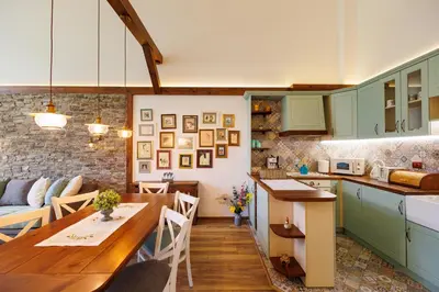 a kitchen and living room with green cabinets and a table at Mountain villa Aleksia- with JACUZZI in Razlog