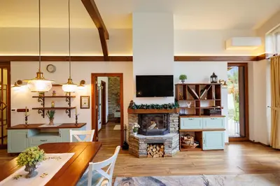 a living room with a table and a fireplace at Mountain villa Aleksia- with JACUZZI in Razlog