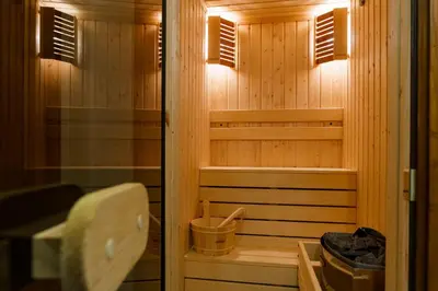 a sauna with wood paneling and two windows at Mountain villa Aleksia- with JACUZZI in Razlog