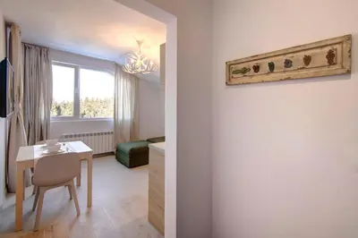 a room with a table and a dining room at Pinewood Apartment Borovets in Borovets