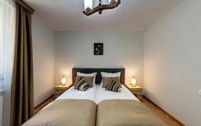 a bedroom with a large bed with two night stands at ШАЛЕТ БЕАТРИС in Razlog