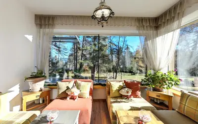 a living room with couches and a large window at ШАЛЕТ БЕАТРИС in Razlog