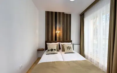 a bedroom with a bed and a large window at ШАЛЕТ БЕАТРИС in Razlog