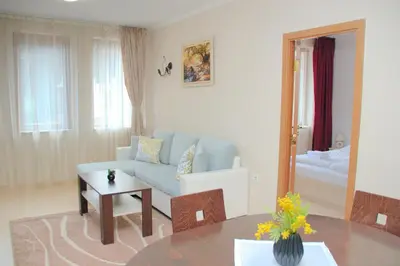 a living room with a blue couch and a table at Гранд Манастира Апартаменти 