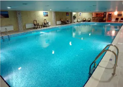 a large swimming pool with blue water in a hotel at Гранд Манастира Апартаменти 