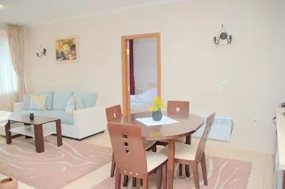a living room with a table and chairs and a couch at Гранд Манастира Апартаменти 