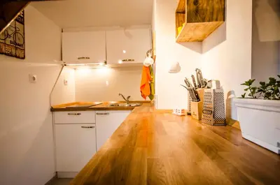 a kitchen with white cabinets and a wooden floor at Off Vitosha Blvd Designer Studio in Sofia