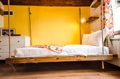a bedroom with a swing bed with a yellow wall at Off Vitosha Blvd Designer Studio in Sofia
