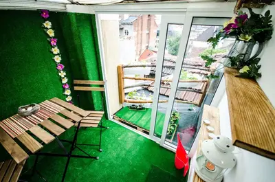 a balcony with a green floor and benches and a window at Off Vitosha Blvd Designer Studio in Sofia