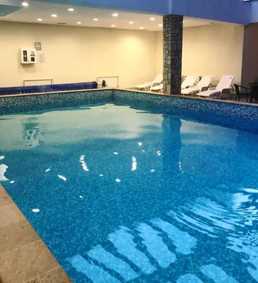 a swimming pool with blue water in a hotel room at Predela 1 - Studio 10 near Bansko Ski Lift in Bansko