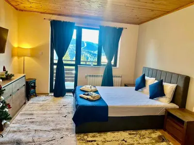 a bedroom with a bed and a large window at Pamporovo Rhodopi Pearl Apartments - Private Apartments in Pamporovo