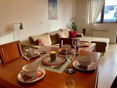 a living room with a table with wine glasses at Pamporovo Rhodopi Pearl Apartments - Private Apartments in Pamporovo