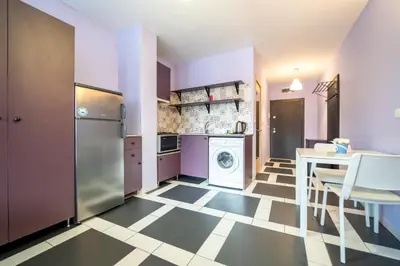 a kitchen with a table and a washing machine at Spacious apartment in the heart of Studentski grad in Sofia