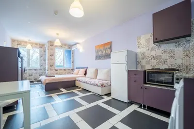 a living room with a couch and a kitchen at Spacious apartment in the heart of Studentski grad in Sofia