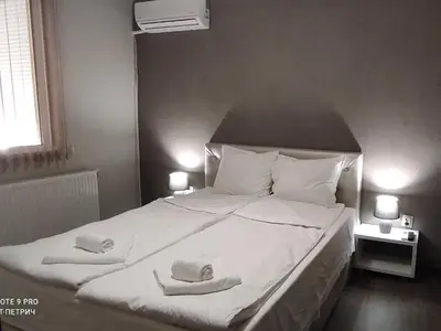 a bedroom with a large white bed with towels on it at BeLApartment in Petrich