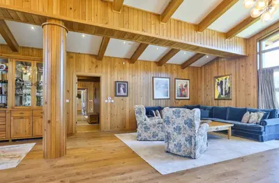 a living room with a blue couch and wooden walls at Luxury Chalets Pirin Golf & Country Club in Bansko
