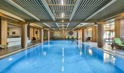a large swimming pool in a large building at Luxury Chalets Pirin Golf & Country Club in Bansko