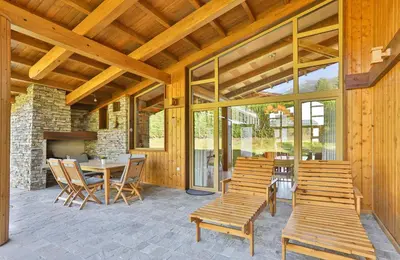 a patio with a table and chairs and a fireplace at Luxury Chalets Pirin Golf & Country Club in Bansko