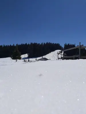 a snow covered field with a ski lodge in the background at Apartment Krasi in Velingrad