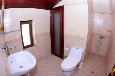 a bathroom with a white toilet and a sink at Self Catering Chalet Kulina in Bansko