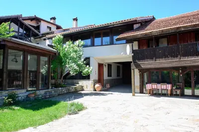 a house with a patio and a building at Self Catering Chalet Kulina in Bansko