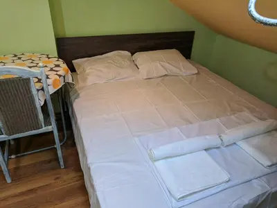 a bed with white sheets and pillows in a room at Midtown Place Apartment Loft таванска стая с баня DORIS 2 in Plovdiv