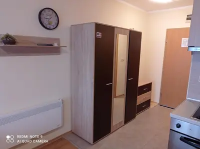 a large cabinet in a kitchen with a clock on the wall at Апартамент-студио в Банско-Разлог,Aspen Golf- C206 in Bansko
