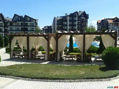 a gazebo with benches in a park with buildings at Апартамент-студио в Банско-Разлог,Aspen Golf- C206 in Bansko