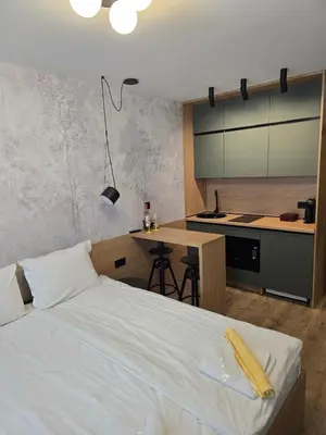 a bedroom with a bed and a kitchen with a table at Студио Пампорово Палас - Pamporovo Palace in Pamporovo