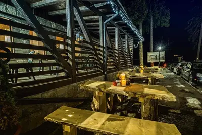 a group of picnic tables on a sidewalk at night at Ски студио Снежанка в Грийн лайф Пампорово in Pamporovo