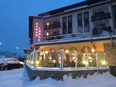 a building with a lit up sign in the snow at Ski Zone at Gondola, Perfect, Fast WiFi, Quiet, Warm in Bansko
