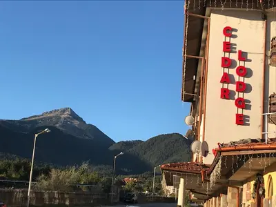 a hotel sign on the side of a building with a mountain at Ski Zone at Gondola, Perfect, Fast WiFi, Quiet, Warm in Bansko