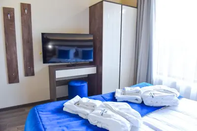 a bedroom with towels on a bed with a tv at Guest house Wishmore in Banya