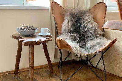 a chair with a furry blanket on it next to a table at Villa Aquila in Beli Iskar