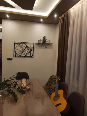 a room with a table and a guitar on the wall at Къща за гости Амая - Сандански in Sandanski