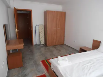 a bedroom with a bed and a wooden cabinet at Monastery 3 Apartments TMF in Pamporovo