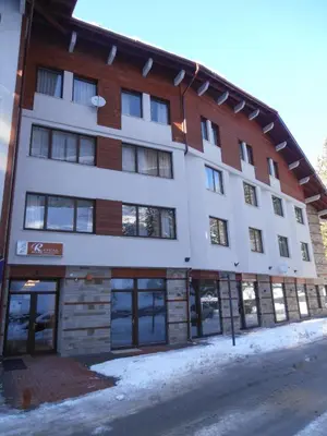 a large building with snow on the ground at Royal House Apartments TMF in Pamporovo