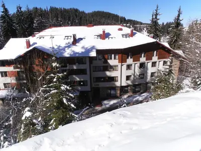 a building with snow on top of a mountain at Royal House Apartments TMF in Pamporovo