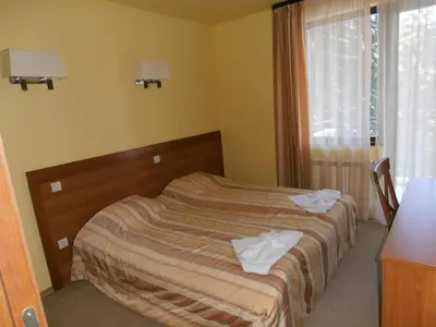 a bedroom with a bed with two towels on it at Royal House Apartments TMF in Pamporovo