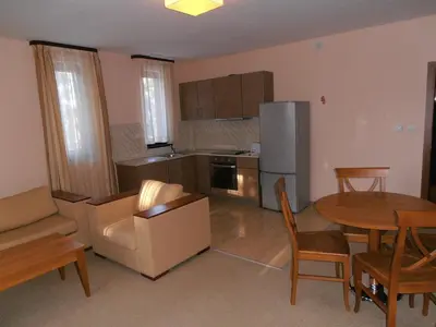 a living room with a kitchen and a table and chairs at Royal House Apartments TMF in Pamporovo