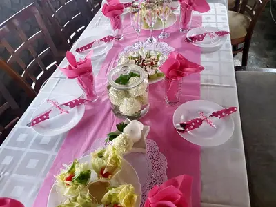 a pink table with plates of food and pink napkins at Family Hotel Chichin in Bansko