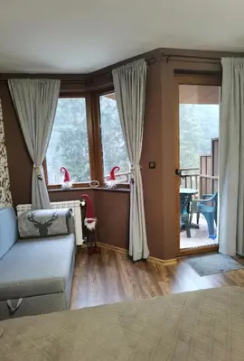 a living room with a couch and some windows at Studio 1 Iceberg Borovets in Borovets