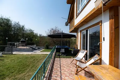 a patio with two chairs and an umbrella at AMAZING view, privacy and comfort - SPA Villa Krasi in Blagoevgrad