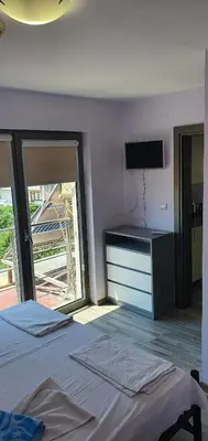 a bedroom with a bed and a flat screen tv at Хотел Дани in Sandanski