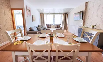 a dining room and living room with a table and chairs at Mountain View Aparthotel in Bansko