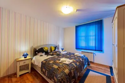 a bedroom with a bed and a blue window at Mountain View Aparthotel in Bansko