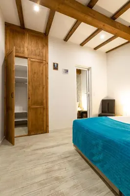 a bedroom with a blue bed and a closet at Къщи за гости Сноуфлейк Snowflake Chalet and Snowflake Lodge in Bansko
